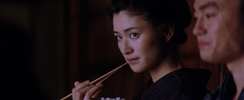 Movie still from “The Last Samurai” (2003), directed by Edward Zwick – A woman holding chopsticks in her mouth while eating; Close Up shot, Low angle