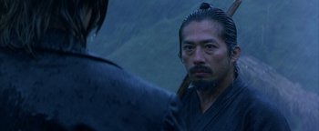 Movie still from “The Last Samurai” (2003), directed by Edward Zwick – A man with a long black beard is looking into a mirror; Close Up shot, Over the shoulder angle