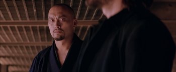 Movie still from “The Last Samurai” (2003), directed by Edward Zwick – A man in a black robe looking at another man in a black robe; Close Up shot, Over the shoulder angle