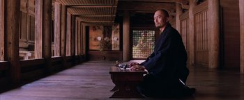 Movie still from “The Last Samurai” (2003), directed by Edward Zwick – A man sitting at a table in a room; Wide shot, Low angle