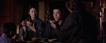 Movie still from “The Last Samurai” (2003), directed by Edward Zwick – A group of people sitting at a table with food; Medium shot, Over the shoulder angle