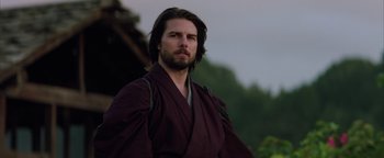 Movie still from “The Last Samurai” (2003), directed by Edward Zwick – A man with long black hair wearing a purple robe; Close Up shot, Low angle