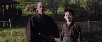 Movie still from “The Last Samurai” (2003), directed by Edward Zwick – A man and a young boy standing next to each other; Medium shot, Low angle