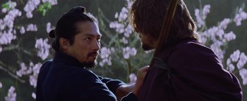 Movie still from “The Last Samurai” (2003), directed by Edward Zwick – A man with long hair and a beard holding a bow and arrow; Close Up shot, Over the shoulder angle