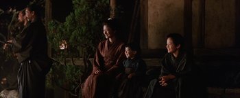 Movie still from “The Last Samurai” (2003), directed by Edward Zwick – A group of people sitting next to each other on top of a bench; Medium shot, Over the shoulder angle