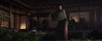 Movie still from “The Last Samurai” (2003), directed by Edward Zwick – A man holding a sword in a room; Medium shot, Low angle