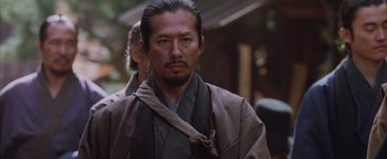 Movie still from “The Last Samurai” (2003), directed by Edward Zwick – A man with a beard wearing a robe and a tie; Close Up shot, Low angle