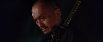 Movie still from “The Last Samurai” (2003), directed by Edward Zwick – A man with a shaved head holding a sword in his hands; Close Up shot, Low angle