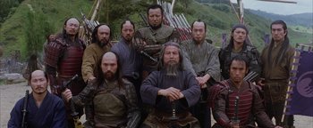 Movie still from “The Last Samurai” (2003), directed by Edward Zwick – A group of men sitting next to each other in front of a wall; Medium shot, Low angle