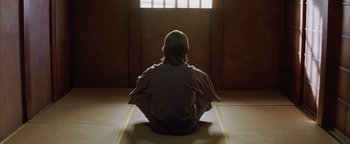 Movie still from “The Last Samurai” (2003), directed by Edward Zwick – A man sitting in a room with his hands in his lap; Medium shot, Low angle