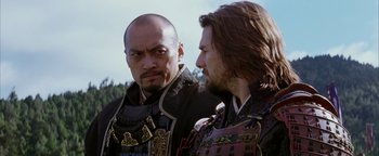 Movie still from “The Last Samurai” (2003), directed by Edward Zwick – Two men are dressed in medieval garb and one has a beard and one has long brown hair; Close Up shot, Over the shoulder angle