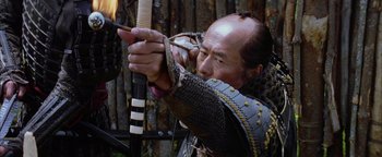 Movie still from “The Last Samurai” (2003), directed by Edward Zwick – An older man is holding a bow and arrow in his hands; Close Up shot, Low angle