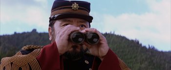 Movie still from “The Last Samurai” (2003), directed by Edward Zwick – A man with a beard wearing a hat and holding a pair of binoculars; Close Up shot, Low angle
