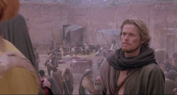 Movie still from “The Last Temptation of Christ” (1988), directed by Martin Scorsese – A group of people gathered in the desert; Medium shot, Over the shoulder angle