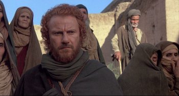 Movie still from “The Last Temptation of Christ” (1988), directed by Martin Scorsese – A group of men standing next to each other on top of a hill; Medium shot, Low angle