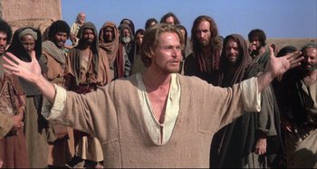 Movie still from “The Last Temptation of Christ” (1988), directed by Martin Scorsese – A man that is standing in front of a group of people; Medium shot, Low angle