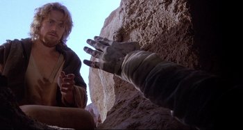 Movie still from “The Last Temptation of Christ” (1988), directed by Martin Scorsese – A person reaching out to a woman in a cave; Close Up shot, Low angle