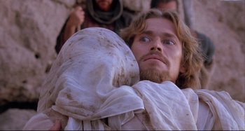 Movie still from “The Last Temptation of Christ” (1988), directed by Martin Scorsese – A man with long hair and a beard is holding a blanket; Close Up shot, Low angle