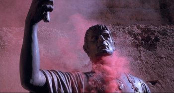 Movie still from “The Last Temptation of Christ” (1988), directed by Martin Scorsese – A statue with pink smoke coming out of its mouth; Medium shot, Low angle