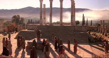 Movie still from “The Last Temptation of Christ” (1988), directed by Martin Scorsese – A group of people standing on top of a stone staircase; Extreme Wide shot, High angle