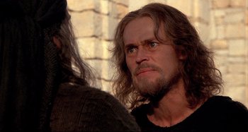Movie still from “The Last Temptation of Christ” (1988), directed by Martin Scorsese – A man with long hair and a goatee looking at another man with long hair and a goatee; Close Up shot, Over the shoulder angle