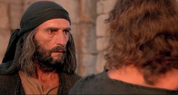 Movie still from “The Last Temptation of Christ” (1988), directed by Martin Scorsese – A man with long hair and a beard looking into a mirror; Close Up shot, Over the shoulder angle