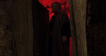 Movie still from “The Last Temptation of Christ” (1988), directed by Martin Scorsese – A man standing in the doorway of a house; Medium shot, Low angle