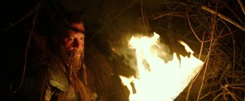 Movie still from “The Last Witch Hunter” (2015), directed by Breck Eisner – A man with long hair and a long beard is in front of a fire; Close Up shot, Over the shoulder angle