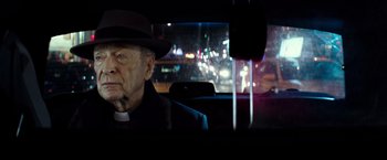 Movie still from “The Last Witch Hunter” (2015), directed by Breck Eisner – An old man wearing a hat sitting in the back of a car; Close Up shot, Over the shoulder angle
