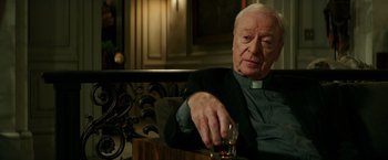 Movie still from “The Last Witch Hunter” (2015), directed by Breck Eisner – An older man sitting at a table with a glass of alcohol; Close Up shot, Over the shoulder angle
