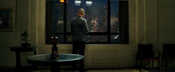 Movie still from “The Last Witch Hunter” (2015), directed by Breck Eisner – A man standing in front of a window looking out at a city; Wide shot, High angle