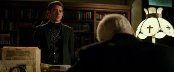Movie still from “The Last Witch Hunter” (2015), directed by Breck Eisner – A man standing in front of another man in front of a book shelf; Medium shot, Over the shoulder angle