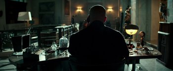 Movie still from “The Last Witch Hunter” (2015), directed by Breck Eisner – A man sitting at a table in a dark room; Medium shot, Over the shoulder angle