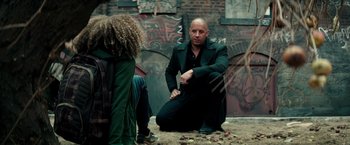 Movie still from “The Last Witch Hunter” (2015), directed by Breck Eisner – A man and a woman sitting on the ground in front of a wall; Medium shot, Over the shoulder angle