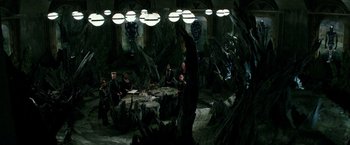 Movie still from “The Last Witch Hunter” (2015), directed by Breck Eisner – A group of people sitting around a table in a dark room; Wide shot, High angle