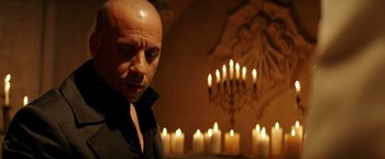 Movie still from “The Last Witch Hunter” (2015), directed by Breck Eisner – A bald man in front of a group of candles; Close Up shot, Over the shoulder angle