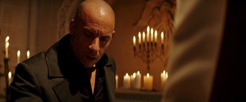 Movie still from “The Last Witch Hunter” (2015), directed by Breck Eisner – A bald headed man in front of candles; Close Up shot, Over the shoulder angle