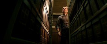 Movie still from “The Last Witch Hunter” (2015), directed by Breck Eisner – A man standing in front of a row of books; Medium shot, Low angle