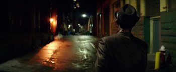 Movie still from “The Last Witch Hunter” (2015), directed by Breck Eisner – A man wearing a hat standing in the middle of an alley at night; Close Up shot, Over the shoulder angle