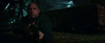 Movie still from “The Last Witch Hunter” (2015), directed by Breck Eisner – A man holding a gun while standing next to a tree; Medium shot, Low angle