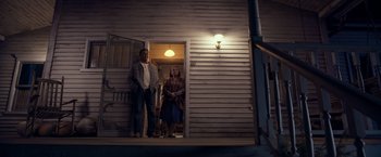 Movie still from “Rambo: Last Blood” (2019), directed by Adrian Grunberg – A man and a woman standing in front of a door; Wide shot, Low angle
