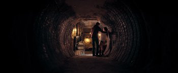 Movie still from “Rambo: Last Blood” (2019), directed by Adrian Grunberg – A man and a woman are standing in a tunnel; Wide shot, Low angle