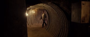 Movie still from “Rambo: Last Blood” (2019), directed by Adrian Grunberg – A man walking through a tunnel in a cave; Wide shot, Low angle