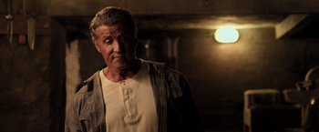 Movie still from “Rambo: Last Blood” (2019), directed by Adrian Grunberg – An older man is standing in a room; Close Up shot, Low angle