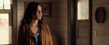 Movie still from “Rambo: Last Blood” (2019), directed by Adrian Grunberg – A woman in a brown jacket looking to her left; Close Up shot, Over the shoulder angle