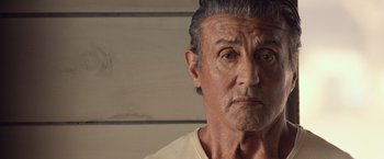 Movie still from “Rambo: Last Blood” (2019), directed by Adrian Grunberg – An older man with a gray beard stares into the camera; Close Up shot, Low angle