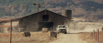 Movie still from “Rambo: Last Blood” (2019), directed by Adrian Grunberg – A truck driving down a dirt road near a barn; Extreme Wide shot, Low angle
