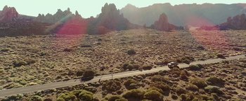 Movie still from “Rambo: Last Blood” (2019), directed by Adrian Grunberg – An aerial view of a car driving on a road in the middle of the desert; Extreme Wide shot, High angle