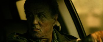 Movie still from “Rambo: Last Blood” (2019), directed by Adrian Grunberg – An old man with a beard is sitting in a car; Close Up shot, Low angle