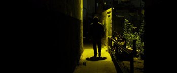 Movie still from “Rambo: Last Blood” (2019), directed by Adrian Grunberg – A man walking down a dark alleyway at night; Wide shot, Low angle